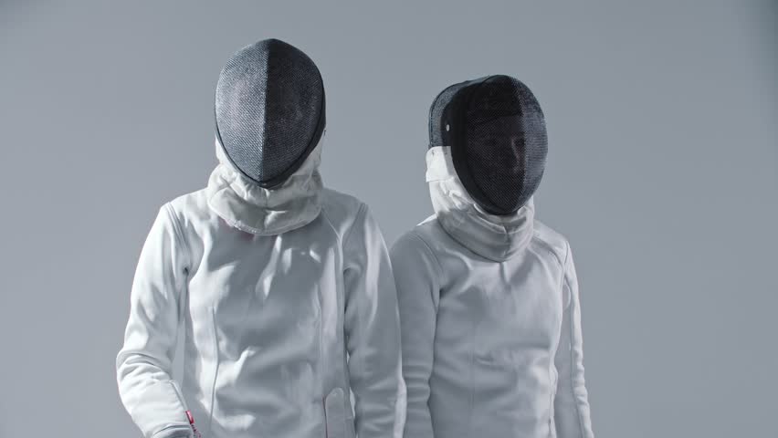 Fencing - two young women fencers takes off their helmets for the camera