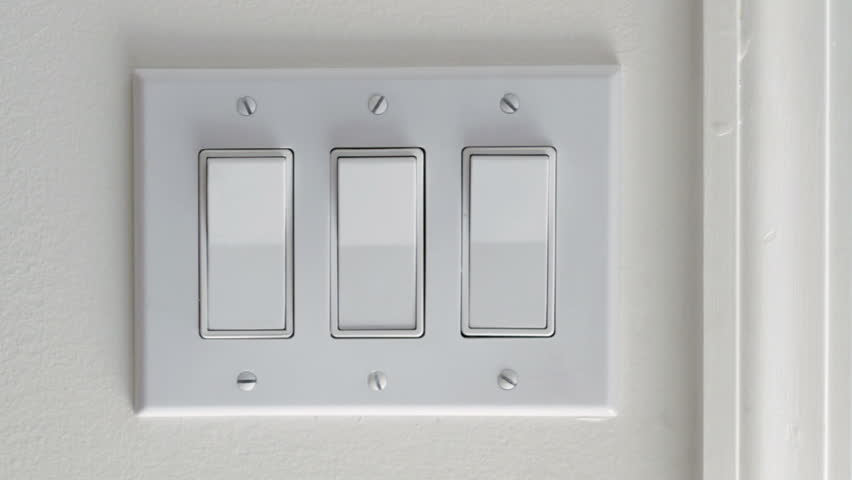 Close up on hand turning light switches on and off.