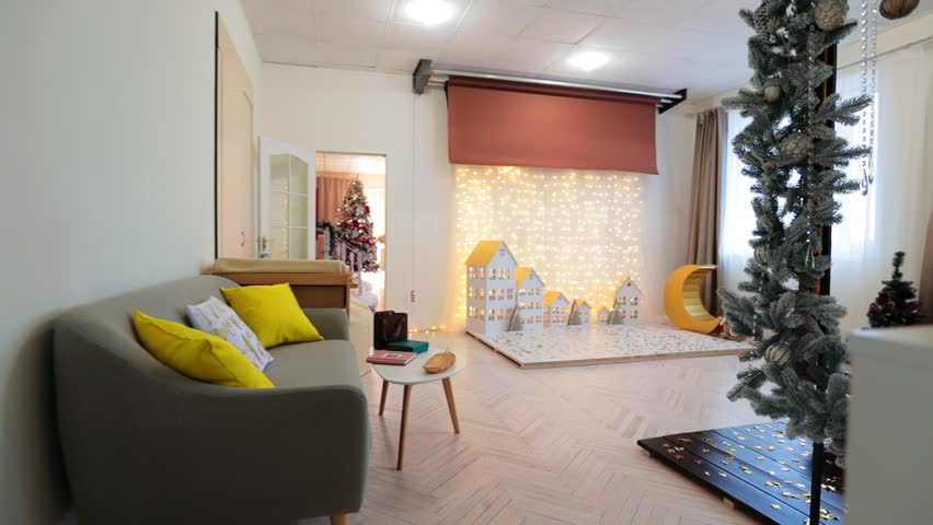 Lovely room with a place decorated with houses lit by the garland. Christmas time decorations in the photo studio.