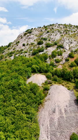 Approaching the rocks where a group of people stand. Rocky panorama of the nature of Spain, Europe. Vertical video.