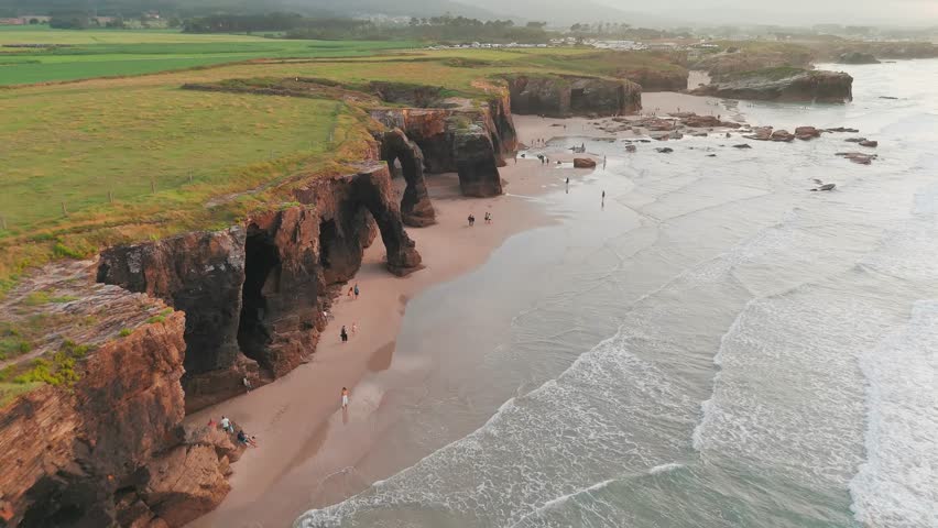 Amazing aerial view of the Playa de Las Catedrales beach in Galicia region at sunset, northern Spain. Beautiful cliff formations on famous Cathedral Beach, Cantabrian Coast 