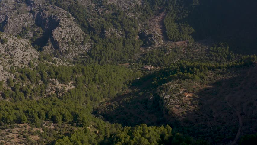 Breathtaking aerial shot of Mallorca landscape. Stunning view of towering mountains shrouded in clouds, under clear, sunny sky. Mallorca, Majorca, Spain, Balearic Islands.