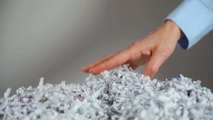 Shredded paper office documents in woman worker hands. Close up 