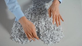 Worker hands arranging shredded office paper into a heart shape, symbolizing recycling and environmental awareness. Top down view - Powered by Shutterstock - Get 15% off with code: PIKWIZARD15