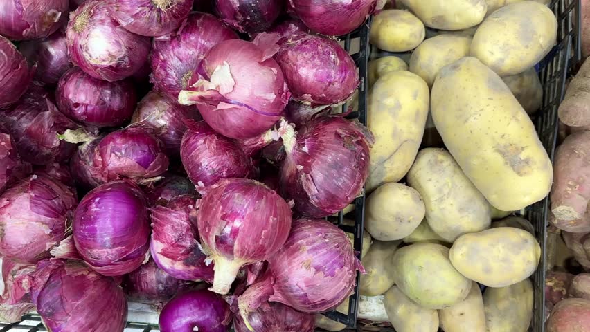 choosing onions, potatoes in a grocery store