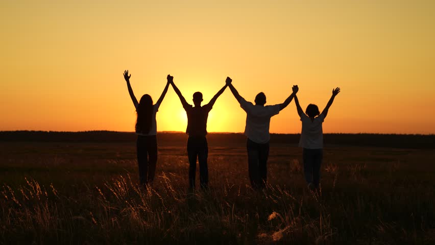Happy team people holding hands raise hands. Teamwork people. Group people teamwork, business group, sun, nature park, sunset. Partnership, help in business concept. Business people united by one idea
