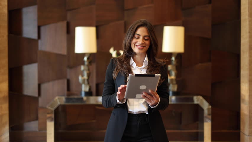 Young, ambitious businesswoman using tablet on the move