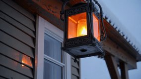 A stunningly beautiful lantern provides warm illumination on a snowy evening outside a charming wooden house - Powered by Shutterstock - Get 15% off with code: PIKWIZARD15