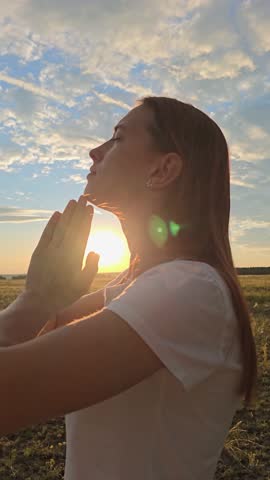 Morning prayer of girl outdoors. Freedom of religion. Young woman praying at sunset, Silhouette. Path of soul to God through prayer. Christian prayer, nature. Era of mercy, kindness, love. Girl, relax