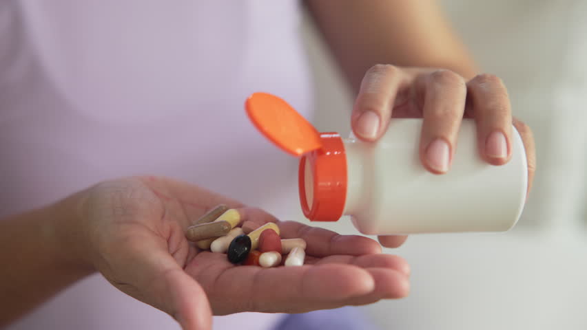 Asia adult aged people middle age happy old woman smile drink vitamin d c e k zinc omega 3 fish oil water pill reduce hot flash dry skin health care sit at home sofa elder aging asian. Take diet food.