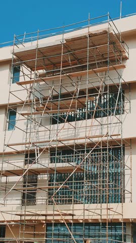 Under construction residential building with Concreate Block structure. 
Exterior view of under construction building with modern design cover with Scaffolding. 
G+3 floor building with Cream color