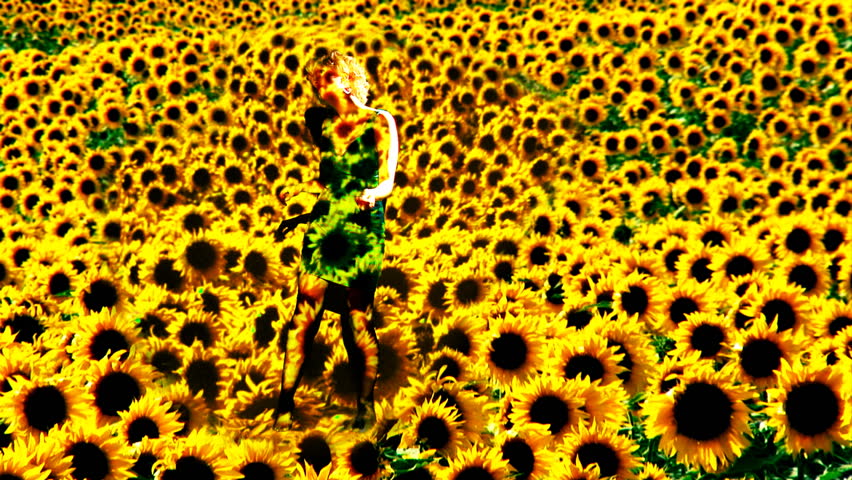 Blonde girl dances to unheard music in a projection of sunflowers. Clip created