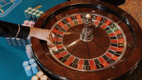 Hands of a casino croupier throwing a ball and spinning a roulette wheel. Playing roulette in a casino. Gambling. Casino concept. - Powered by Shutterstock - Get 15% off with code: PIKWIZARD15