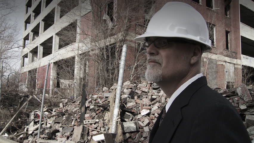 Developer walks into shot and looks around at the collapsed buildings around