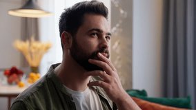 Joyful happy thoughtful Caucasian man male guy homeowner businessman thinking touching beard chin gesture think brainstorming having idea insight eureka raise finger indoors living room home apartment - Powered by Shutterstock - Get 15% off with code: PIKWIZARD15