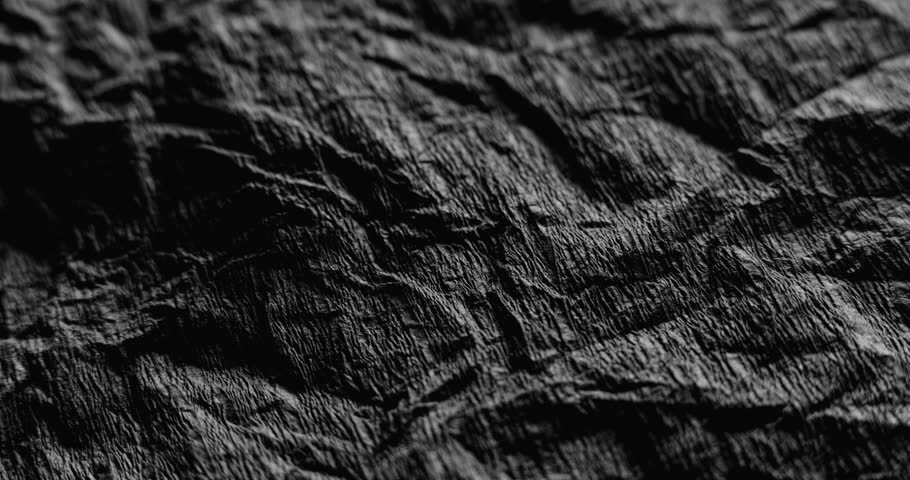 Close-Up of Crumpled Black Texture in Slow Motion. Sow-motion video of a crumpled black texture with smooth camera movement. Perfect for backgrounds, design, cinematic projects.
