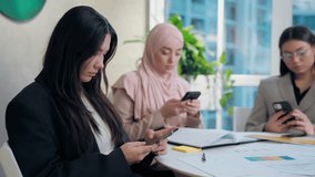 Modern multiethnic women females diversity team girls coworkers businesswomen business colleagues using mobile phone smartphone online app internet addiction scrolling social media indoors office - Powered by Shutterstock - Get 15% off with code: PIKWIZARD15