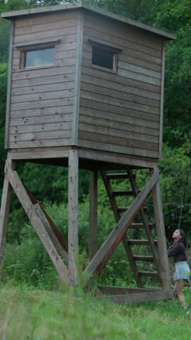A beautifully crafted Wooden Observation Tower set in the heart of Natures serene landscape. girl climbs observation tower slow motion