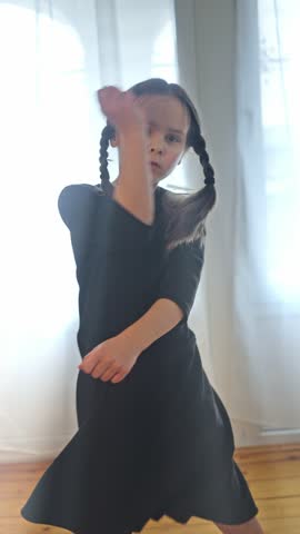 A Captivating Expressive Child Dressed in a Black Dress Performing Graceful and Dramatic Movements