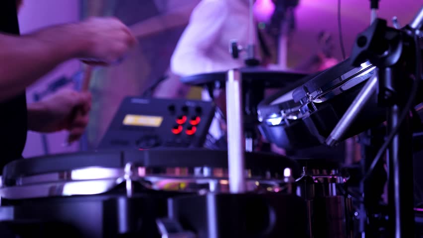 A drummer plays drums on a blue background. Beautiful special effects of light and smoke. The process of playing a musical instrument. The concept of music.