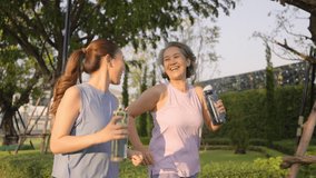 Young adult child workout outdoor public park run walk hold water bottle with mature middle age old mum. Love health care older mom asia elder people happy family protect aging fun joy city life sport - Powered by Shutterstock - Get 15% off with code: PIKWIZARD15