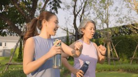 Young adult child workout outdoor public park run walk hold water bottle with mature middle age old mum. Love health care older mom asia elder people happy family protect aging fun joy city life sport - Powered by Shutterstock - Get 15% off with code: PIKWIZARD15