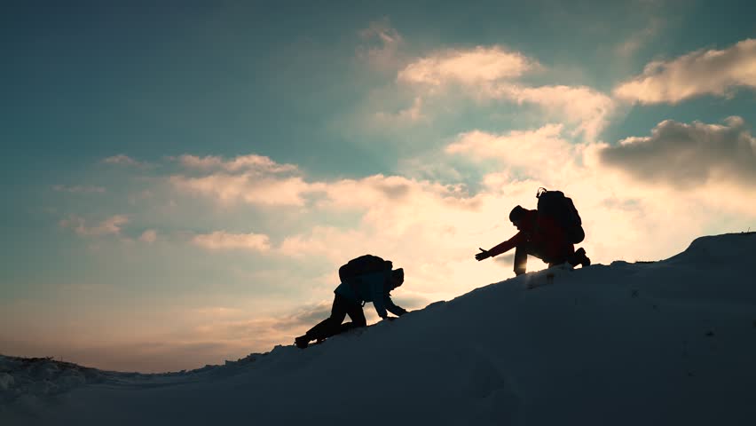 Travelers climb one after another on rock Climbers silhouettes stretch their hands to each other climbing to top of hill. Teamwork of business people. Go towards your goal. Team of businessmen victory
