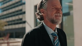 A mature businessman smiles as he walks through the city. He conveys success, experience, and leadership. Perfect for corporate and motivational projects. - Powered by Shutterstock - Get 15% off with code: PIKWIZARD15