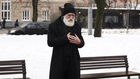 An elderly man suddenly clutching chest in pain, suffering from heartache in a snowy park - Powered by Shutterstock - Get 15% off with code: PIKWIZARD15