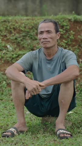 asian shepherds rest sitting next to his hat without moving in vietnam