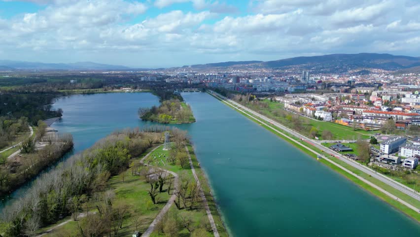 Aerial drone view of Park Jarun in Zagreb, showcasing stunning blue water, lush greenery, and the nearby Sava River Park features excellent bicycle roads, perfect for cycling and outdoor activities