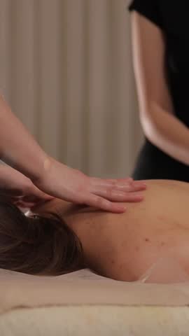 Two female therapists giving relaxing massage to woman in tranquil spa. Rejuvenation and wellness therapy. 