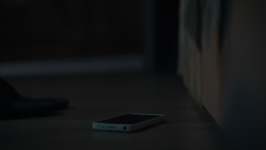 The alarm goes off and the screen of phone lying next to the bed lights up. The man reaches for it his fingers instantly turning off the annoying signal. Early morning activities in a room at home