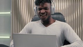 Amazed wonder excited emotional African American carefree man guy male wearing headphones looking laptop computer screen say wow good new success programmer hacker achieve in futuristic white studio - Powered by Shutterstock - Get 15% off with code: PIKWIZARD15