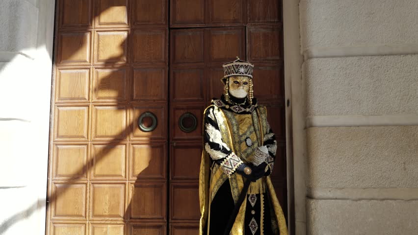 Venice, Italy - People dressed in carnival masks are photographed by tourists in the scenery of the ancient Venetian palaces