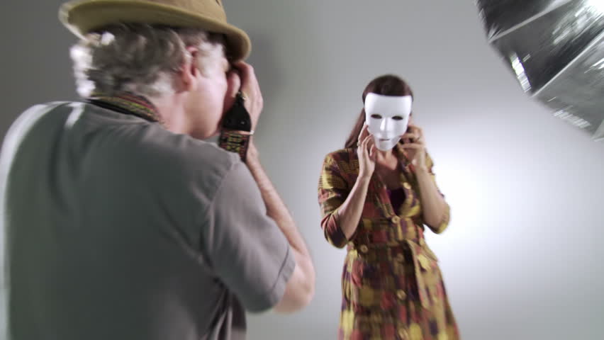 Photographer tries to reveal the person behind the mask as he takes pictures of