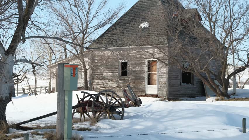 small abandoned house in the field covered with snow
