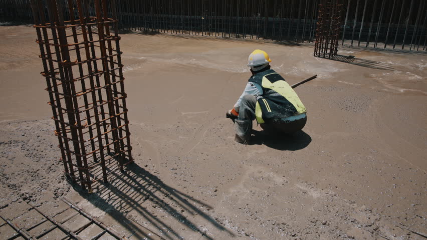 Construction worker smoothing concrete surface