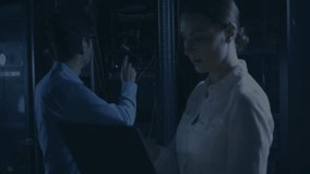 Working on servers, technicians analyzing encryption data overlay in dark room. Cybersecurity, technology, data analysis, IT professional, networking, digital - Powered by Shutterstock - Get 15% off with code: PIKWIZARD15