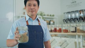 Eco friendly shop owner using digital tablet to check bio organic products stock in container dispenser at plastic free grocery store. Sustainable small local business SME startup go green market. - Powered by Shutterstock - Get 15% off with code: PIKWIZARD15