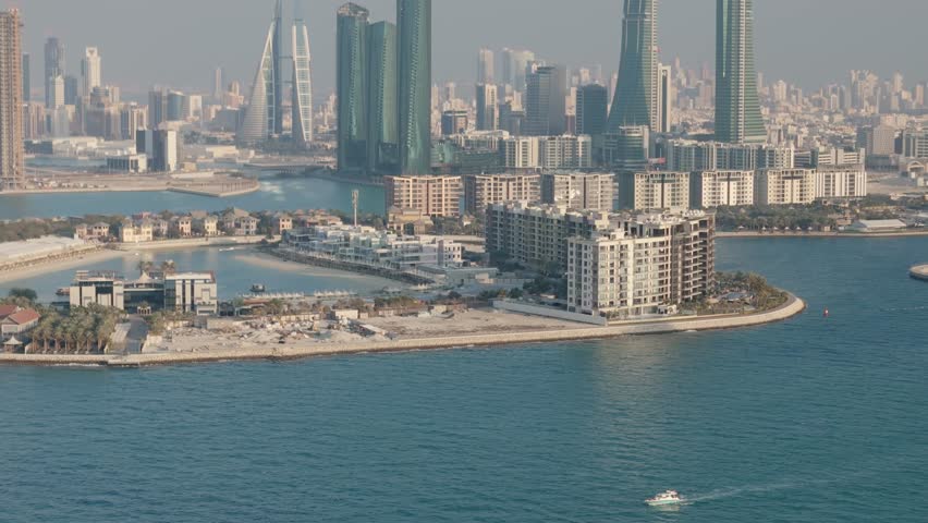 Manama Bahrain, Reef Island and downtown skyline with small boat in foreground, aerial drone shot
