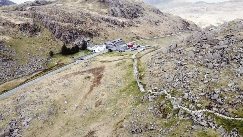 A stunning aerial view of Pen-y-Pass in Snowdonia National Park, Wales, showcasing rugged mountain terrain, winding hiking trails, and the iconic starting point for ascents of Snowdon (Yr Wyddfa).