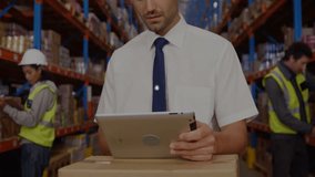 Using tablet with network connections, businessman in warehouse setting. logistics, technology, digital, connectivity, enterprise, management - Powered by Shutterstock - Get 15% off with code: PIKWIZARD15