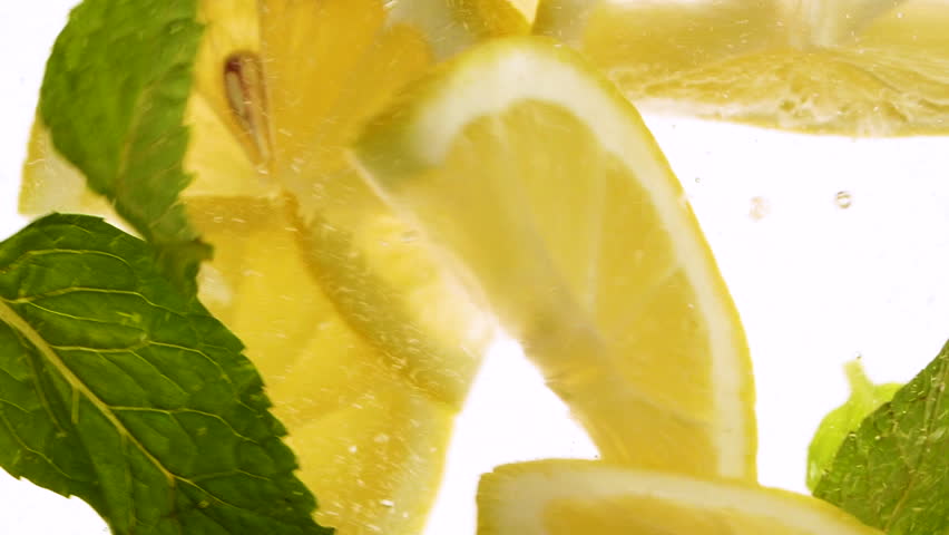 Slow motion slices of lemon or orange fruit and mint leaves splashing in water - Powered by Shutterstock - Get 15% off with code: PIKWIZARD15
