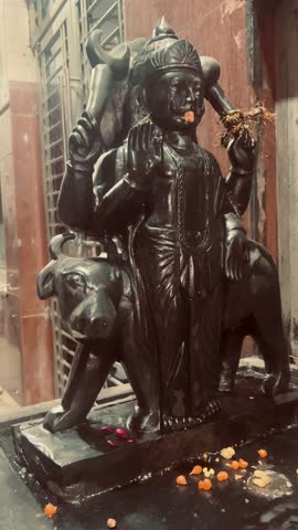 bronze statue of Shani Dev, Hindu god of India, at night in temple.
