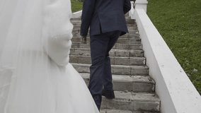 Young bride and groom climb the stone stairs up in the park they are very happy on this wedding day - Powered by Shutterstock - Get 15% off with code: PIKWIZARD15