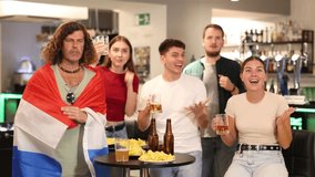  Group of friends fans watching match cheering with Netherlands flag in bar - Powered by Shutterstock - Get 15% off with code: PIKWIZARD15