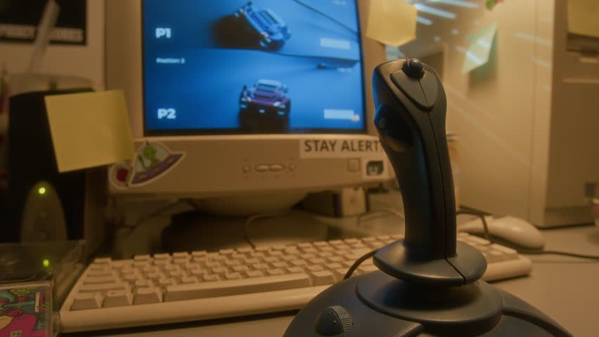 Close up shot of retro PC computer and racing videogame on screen in nostalgic setting lit by warm light, copy space