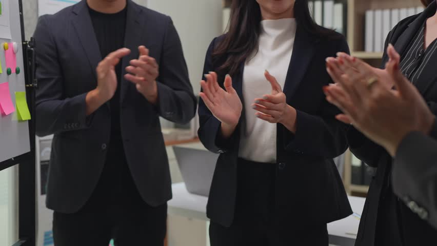 Professional business team clapping hands, celebrating collaborative success and expressing genuine workplace appreciation during team meeting