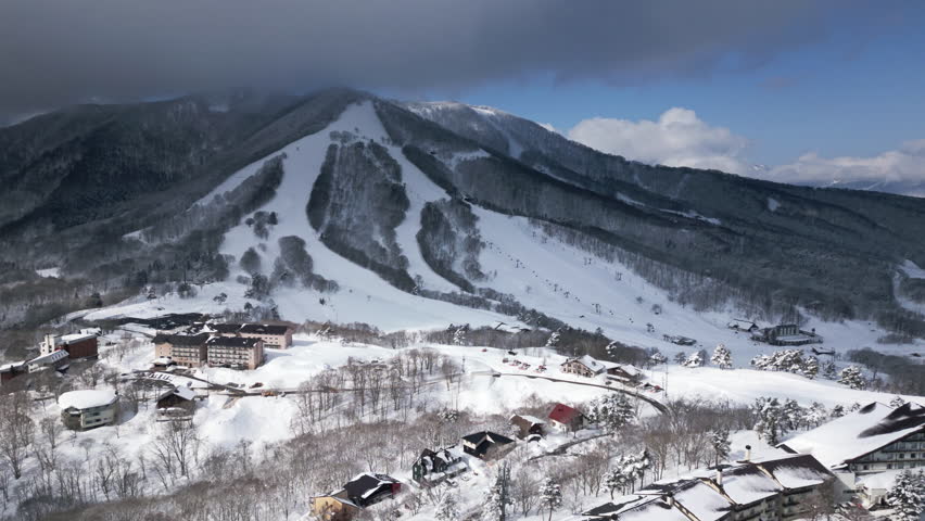 Aerial orbit of Madarao ski resort, Nagano. Snowy mountain, slopes in winter
